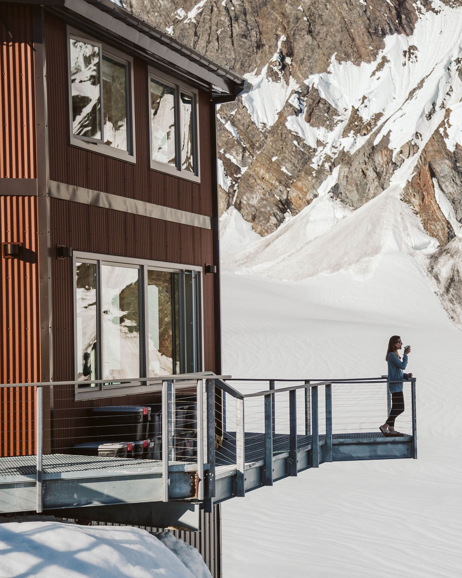 Image may contain Nature Outdoors Scenery Person Architecture Building Housing Handrail Clothing Glove and House